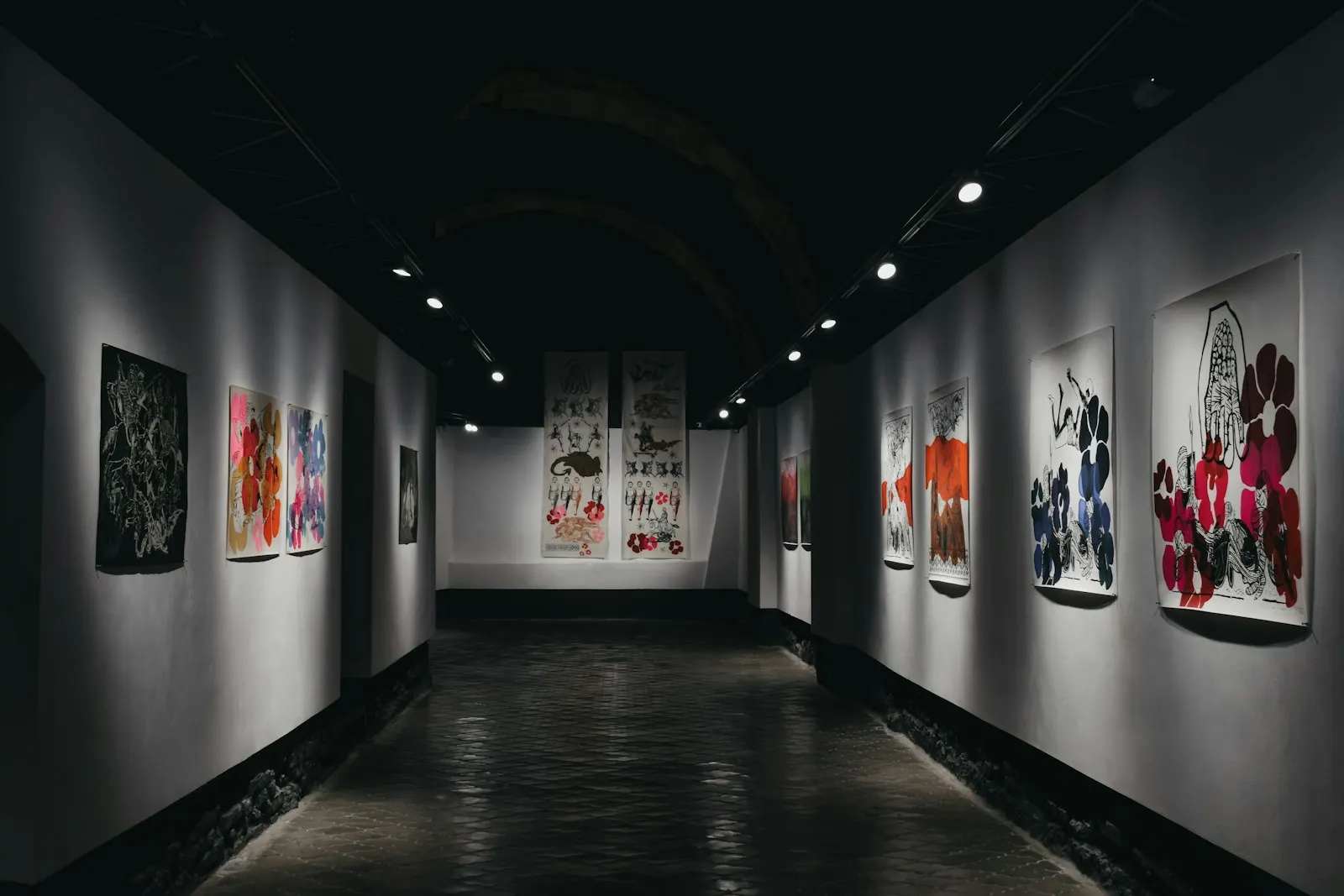 Gallery corridor with framed posters lit along both walls